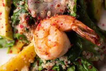 Fried king prawns with brown rice and vegetables: red pepper and onions. Served on a wooden plated with cut chives, spring onions and two pieces of lemon.Macro perspective, nobody, restaurant, menu.