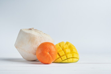 Naklejka na ściany i meble Half of mango, mandarin and fresh coconut on white background.