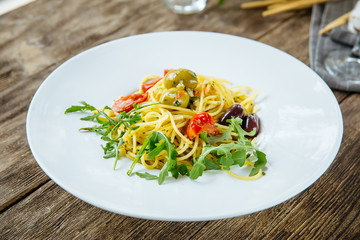 Closeup on spaghetti pasta olives and tomatoes