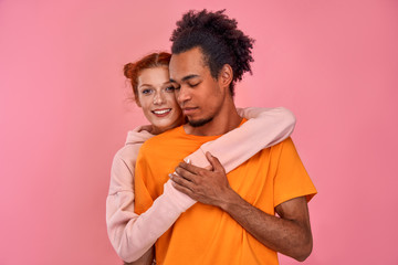 Love affair. Portrait of charming interracial couple of millennial cheerful positive ginger woman...