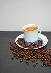 Cup of coffee and coffee beans, black and white background