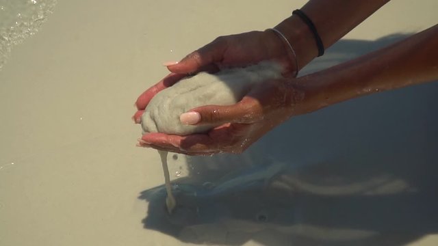 Hand holding white sand at beach. Famous white silica sand. Whitehaven beach, Whitsundays. Turquoise ocean, white sand. Travel, holiday, vacation, paradise. Shot in Hill Inlet, Queenstown, Australia.