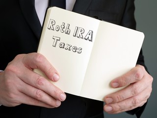 Business concept about Roth IRA Taxes with sign on the page.