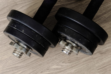 black color old rusty dumbbells on wood floor surface