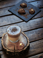 Top view of homemade creamy dalgona coffee along with some homemade cookies, on top of a rustic table. Dark photography