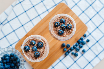 Delicious and delicate creamy Italian dessert Panna Cotta made from chia seeds in milk and chocolate mass. Decorated with fresh blueberries and crumbs of milk chocolate. Healthy eating. Diet.