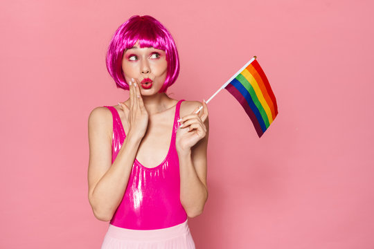 Image of happy woman making kiss lips and holding rainbow flag