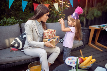 young female brunette holding birthday present and talking to a sweet little girl. birthday , leisure, communication concept