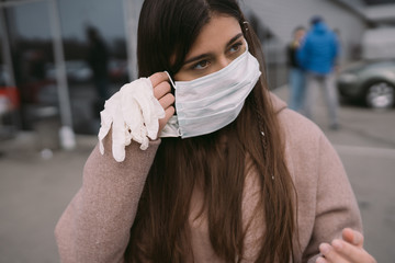 Woman puts on a protective medical mask.