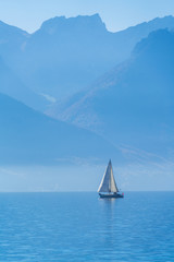 Fototapeta premium A small sailing yacht on the Lake Geneva and the Alps, Switzerland