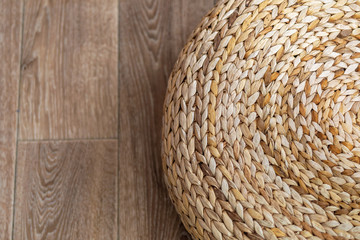 Round brown wicker chair in vintage style on the wooden floor. Top view.