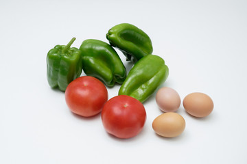 Tomato bell peppers and eggs on a white table