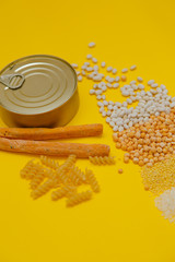 Food supplies crisis food stock for quarantine isolation period on yellow background. Rice, pasta, beans, groats canned food, snacks. Food delivery, coronavirus crisis concept. Close up