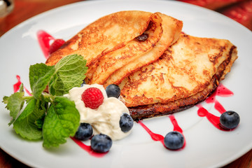 Close-up delicious pancakes, with fresh blueberries and strawberries.
