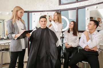 Young people with professional hairdresser and model during courses in salon