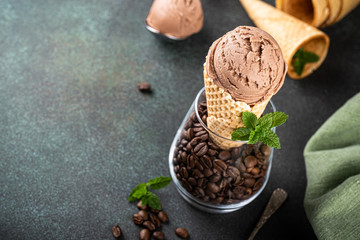 Delicious coffee or chocolate ice cream in waffle cone for dessert. Summer healthy food concept, lactose free. Copy space.