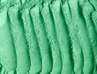 Green cosmetic clay powder (alginate facial mask, spirulina body wrap) texture close up, selective...