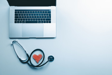 La scrivania di un medico con computer stetoscopio e simbolo del cuore