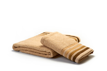 Stack of clean soft light brown towels on a white background, set for the bathroom, hygiene