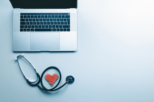 La scrivania di un medico con computer stetoscopio e simbolo del cuore
