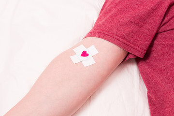 man with a band-aid on his hand, heart on a band-aid, blood donor concept