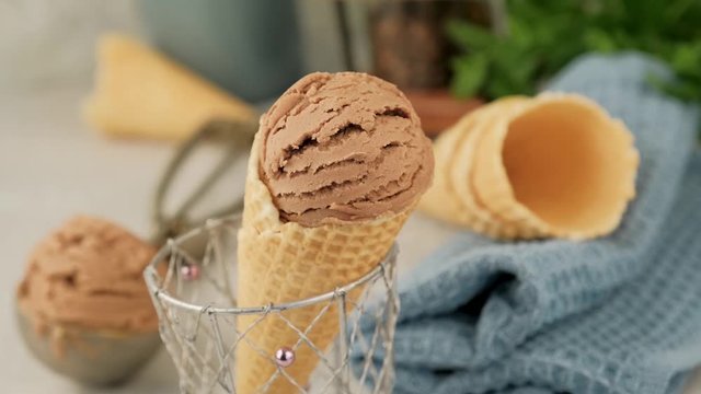 Delicious summer dessert coffee ice cream in waffle cone. Summertime healthy food concept, lactose free. Camera zoom out