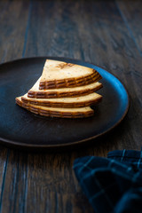 Spicy Circassian Triangle Smoked Cheese Slices on Dark Wooden Plate with Spices.