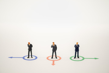 Fototapeta premium Businessman miniature people figure thinking in circle direction forward on white background with copy space using for business,marketing and financial concept.