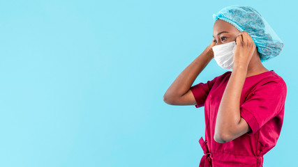 Female black doctor arranging her medical mask