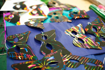 Crafting masks on a table with various designs on them.