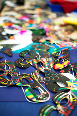 Crafting masks on a table with various designs on them.