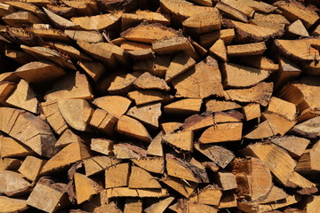 texture of pine firewood. Chipped firewood is on the heap. Woodpile of firewood close-up. A stack of dry firewood, visible texture and cracks in the tree. selective focus.