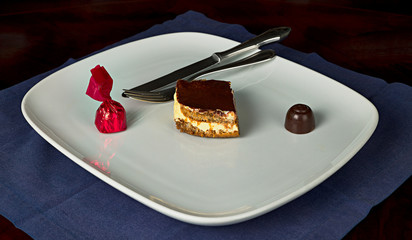 Plato con un trozo de tiramisú y 2 bombones de chocolate