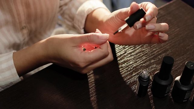 girl paint nails with gel at home. Woman doing gel manicure. 
