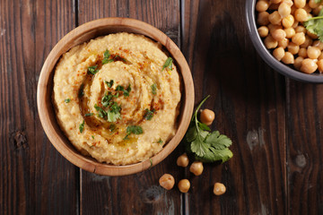 bowl of hummus on wood background