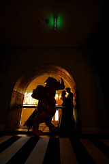 Silhouettes of a young beautiful couple - a girl in a magnificent dress and a guy in a black shirt 