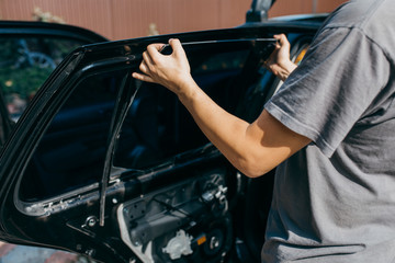 Fototapeta na wymiar Examining and repairing a car outdoors.