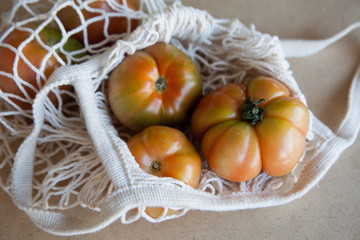 String bag so as not to use a plastic bag with juicy and ripe tomatoes. Natural daylight. View from above.