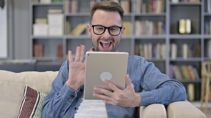 Portrait of Cheerful Young Designer doing Video Chat on Tablet