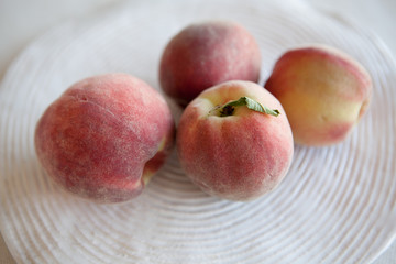 Fresh and juicy peaches s in a ceramic plate. Natural light