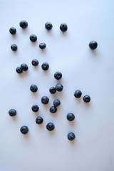 Blueberries scattered on the table. White background. Natural light. Top view 
