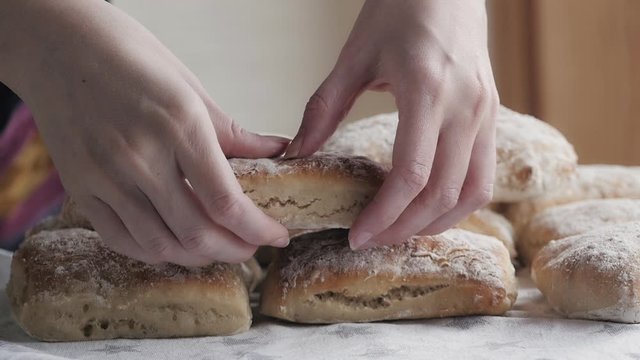 Hands Tear Freshly Baked Bread Closeup. Slow Motion. Breakfast, Nutrition, Home Cooking Concept. 