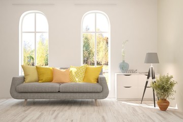 Stylish room in white color with sofa and autumn landscape in window. Scandinavian interior design. 3D illustration