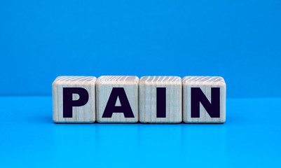 concept word PAIN on cubes on a blue background