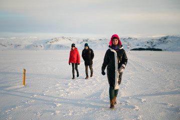 a group of friends goes through a snowy field to a crashed plane in Iceland