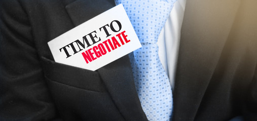 Time to negotiate words on a card in businessman's pocket. Compromise in business concept