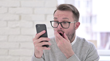 Shocked Creative Man Reacting to Loss on Smartphone