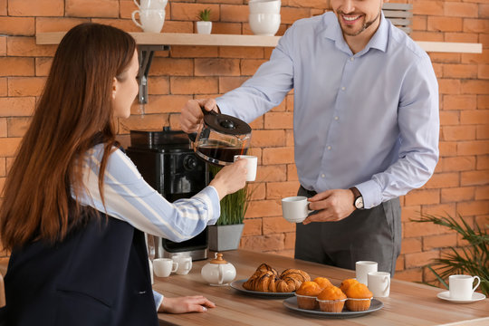 Colleagues drinking coffee in kitchen of office