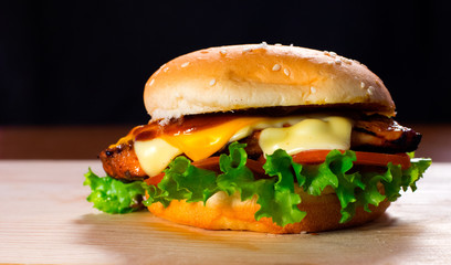 Fresh and Juicy Burger on a Wooden Table with Cheese Lettuce and Tomato