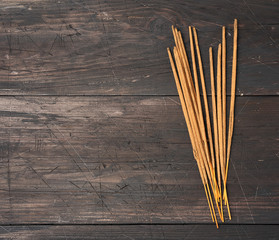 stack of incense sticks for rituals on a brown wooden table